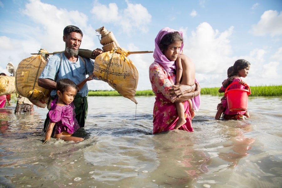 A Rohingya family wades through water crossing the border from Myanmar into Bangladesh. —UNHCR Photo