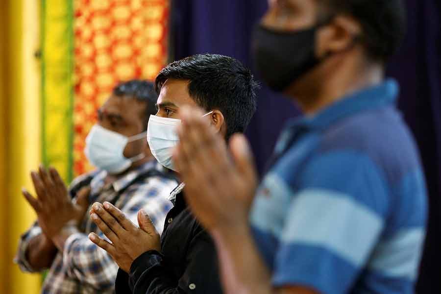 Migrant workers pray at a temple, before enjoying time off at Little India, as part of a pilot programme to allow fully vaccinated migrant workers back to the community after more than a year of movement curbs due to the coronavirus disease (COVID-19) outbreak, in Singapore on Wednesday –Reuters photo