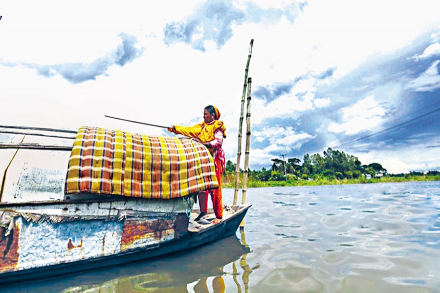 Anjuman Begum, a water gypsy, is placing a mattress over the rooftop of their boat for drying in the sun — bdnews24.com