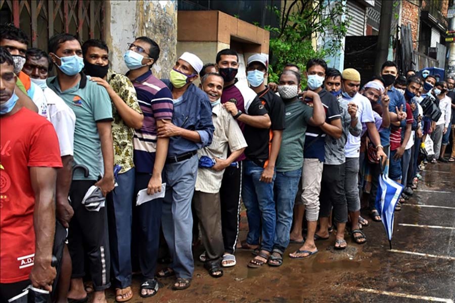 People wait in line for about 7-8 hours as the mass vaccination starts at the Chittagong General Hospital, in Chittagong, Bangladesh. PHOTO - Anadolu Agency