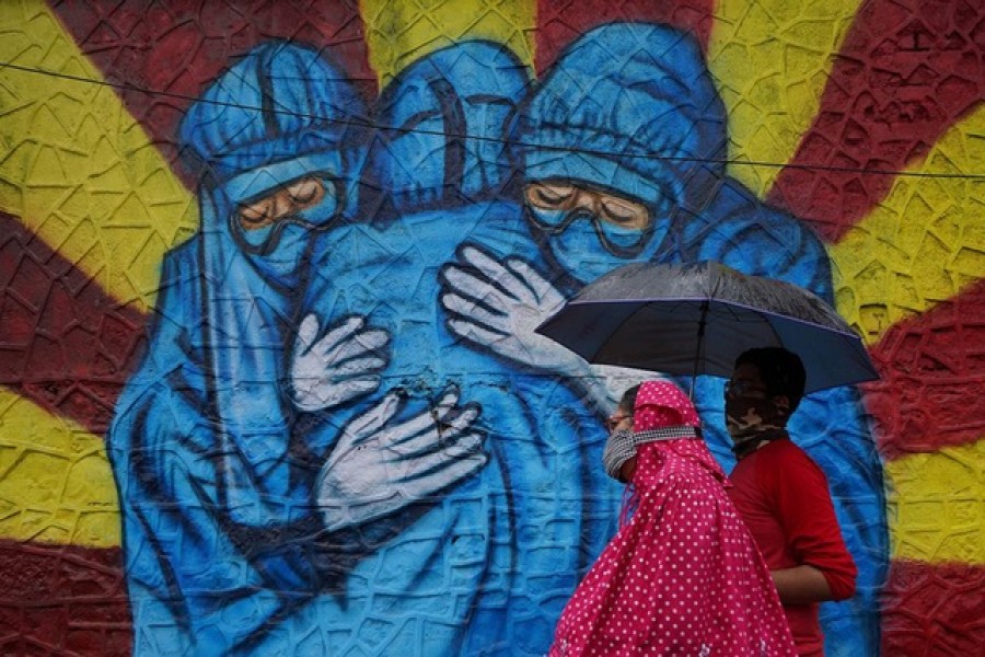 A woman and her son walk past a graffiti on a street, amidst the coronavirus disease (Covid-19) pandemic, in Mumbai, India, December 1, 2021 – Reuters/Hemanshi Kamani/file photo