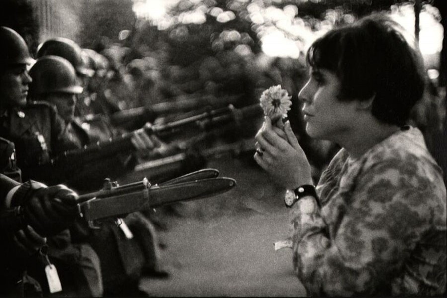 Jan Rose Kasmir, a protester holding a flower in front of the firearms of Police during an anti Vietnam war rally in Pentagon in 1967.