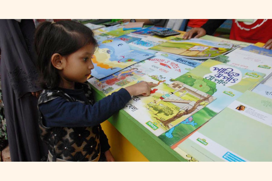 A children is browsing books in the Ekushey Book Fair. Learning Bangla correctly becomes a big challenge for the young generation —UNB Photo