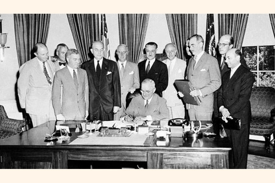 US President Harry S. Truman is signing the NATO alliance pact before members of Congress, 1949. —www.historytoday.com Photo