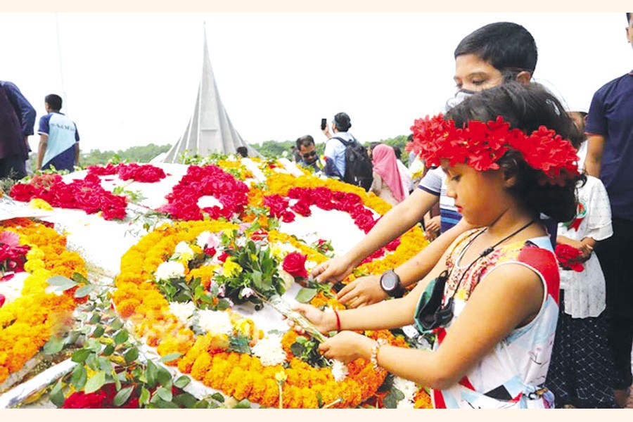Children lay a wreath in memory of the fallen heroes of the Liberation War on Independence Day at the National Memorial in Savar —bdnews24.com photo